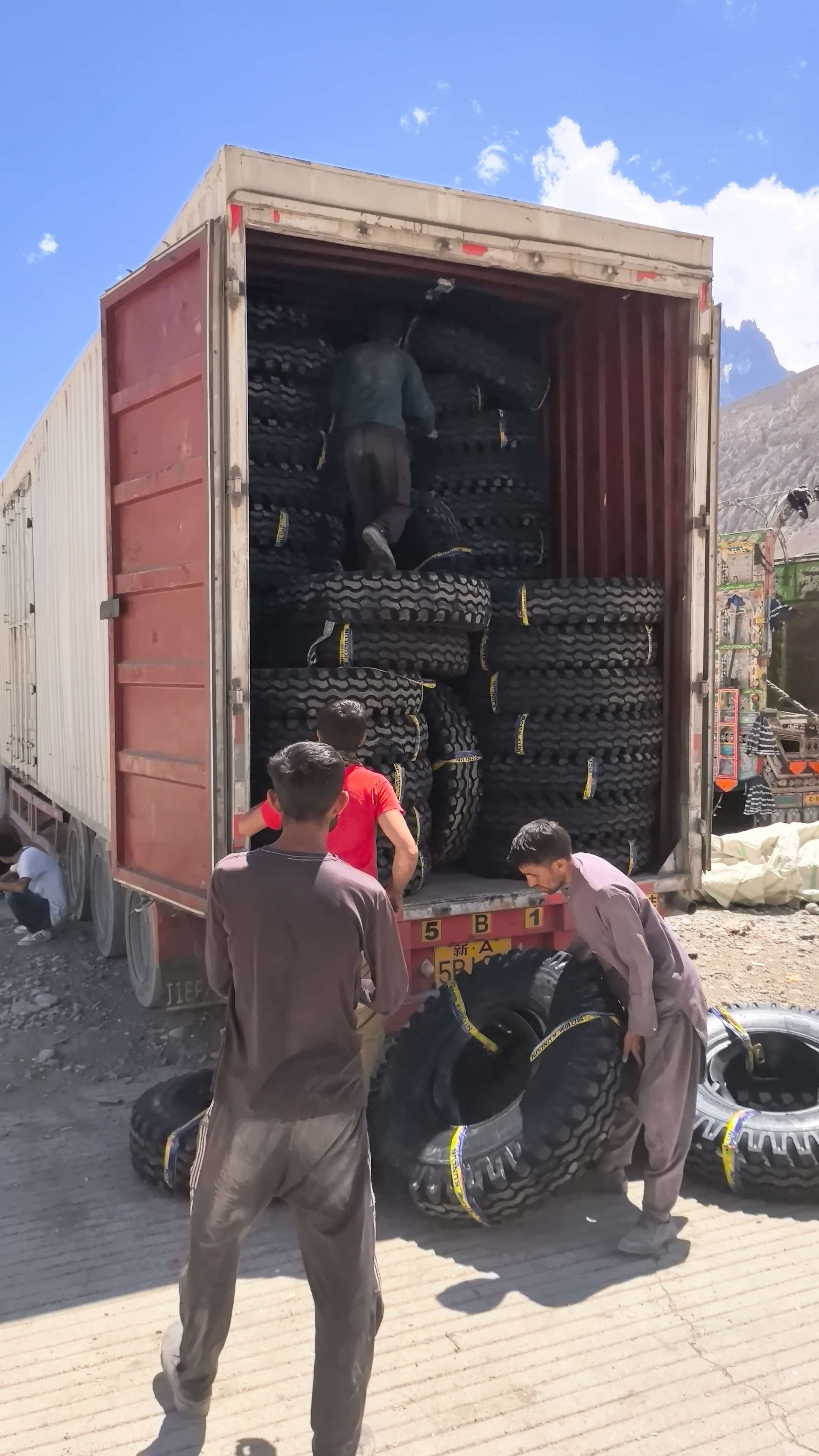 Customer team unloading tires from a shipping container